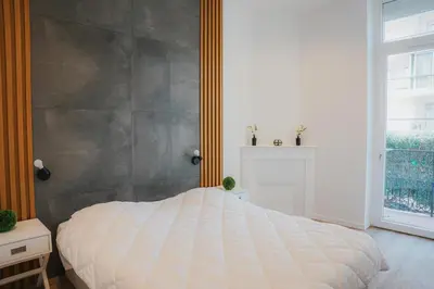 a bedroom with a large white bed and a window at Cozy Home Cannes in Cannes