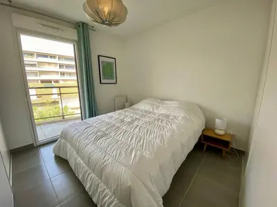 a bedroom with a white bed and a window at Cannes proche Croisette - 3 P tout confort avec balcon in Cannes