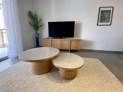 a living room with two tables and a tv at Cannes proche Croisette - 3 P tout confort avec balcon in Cannes