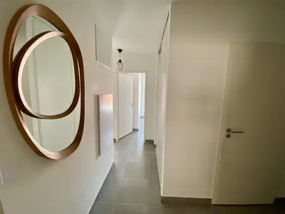 a mirror on a wall next to a hallway at Cannes proche Croisette - 3 P tout confort avec balcon in Cannes