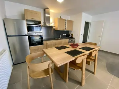 a kitchen with a wooden table and a refrigerator at Cannes proche Croisette - 3 P tout confort avec balcon in Cannes