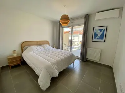 a bedroom with a bed and a large window at Cannes proche Croisette - 3 P tout confort avec balcon in Cannes