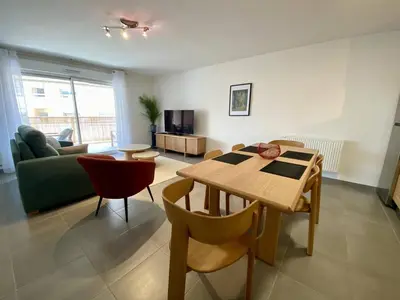 a living room with a table and a couch at Cannes proche Croisette - 3 P tout confort avec balcon in Cannes
