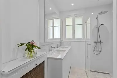 a white bathroom with two sinks and a shower at REF 2177- Exceptional Villa in the Heart of Cannes 5mins from La Croisette in Cannes