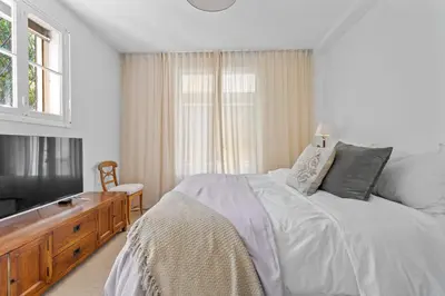 a white bedroom with a bed and a television at REF 2177- Exceptional Villa in the Heart of Cannes 5mins from La Croisette in Cannes