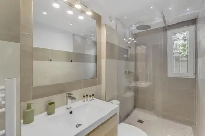 a bathroom with a white sink and a shower at Modern 2 chambres - Jardin - rue du Martinez in Cannes