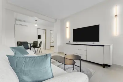a living room with a couch and a flat screen tv at Modern 2 chambres - Jardin - rue du Martinez in Cannes