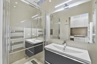 a white bathroom with two sinks and a mirror at Centre Cannes - 2 Chambres - Proche Palais - Calme in Cannes