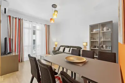 a dining room and living room with a table and chairs at Centre Cannes - 2 Chambres - Proche Palais - Calme in Cannes