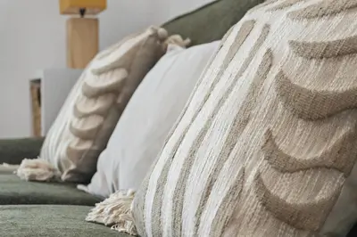 a pile of pillows sitting on a couch at Centre Cannes - 2 Chambres - Proche Palais - Calme in Cannes