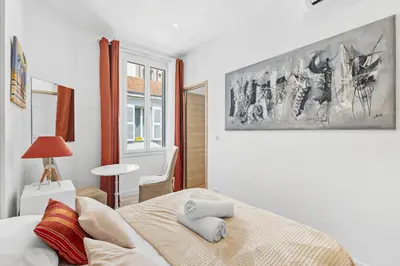 a bedroom with a bed and a painting on the wall at Centre Cannes - 1 Chambre - Proche Palais - Calme in Cannes