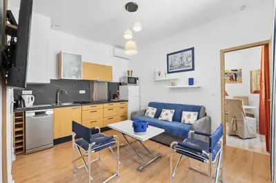 a living room with a couch and a table and chairs at Centre Cannes - 1 Chambre - Proche Palais - Calme in Cannes