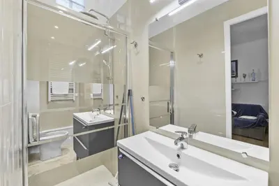 a white bathroom with two sinks and a mirror at Centre Cannes - 1 Chambre - Proche Palais - Calme in Cannes