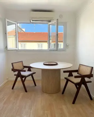 an empty room with a table and two chairs at Chic studio Palais 2 min away in Cannes
