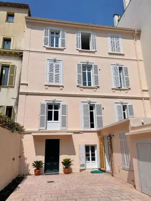 a pink building with white windows and a driveway at Studio La Croisette Cannes La Croix d'Or 2 in Cannes