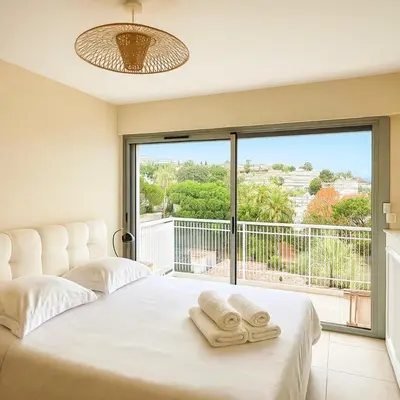 a bedroom with a bed and a large window at Apartment Center of Cannes in Cannes