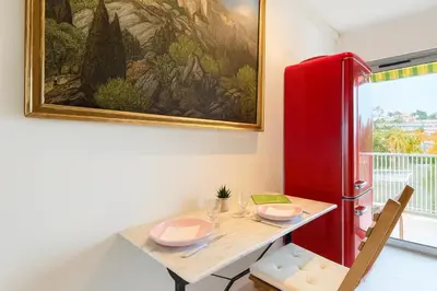 a dining room with a red refrigerator and a table at Apartment Center of Cannes in Cannes