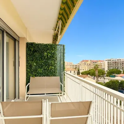 a white chair on a balcony with a view at Apartment Center of Cannes in Cannes