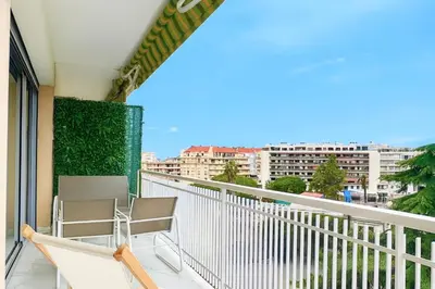 a balcony with chairs and a view of a city at Apartment Center of Cannes in Cannes