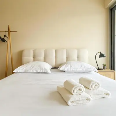 a white bed with two folded towels on it at Apartment Center of Cannes in Cannes
