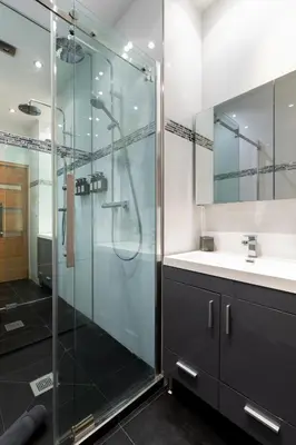 a bathroom with a glass shower and a sink at Le Miramar Apartment Sea View in Cannes