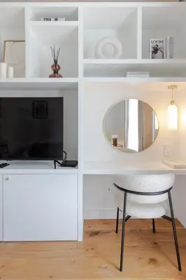 a white living room with a table and a mirror at Le Miramar Apartment Sea View in Cannes