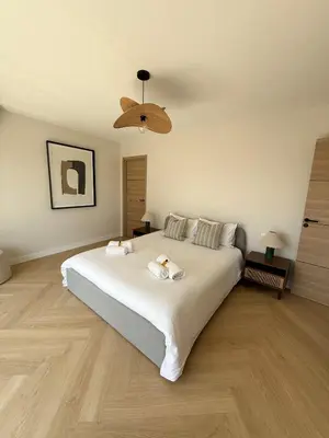 a bedroom with a large white bed with a ceiling at Square Croisette in Cannes