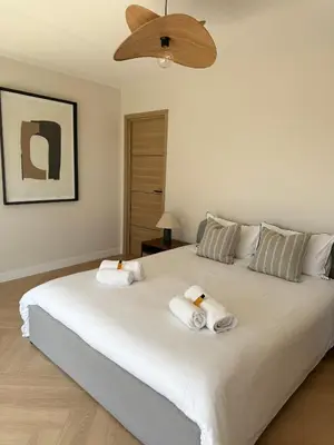 a bedroom with a large white bed with towels on it at Square Croisette in Cannes
