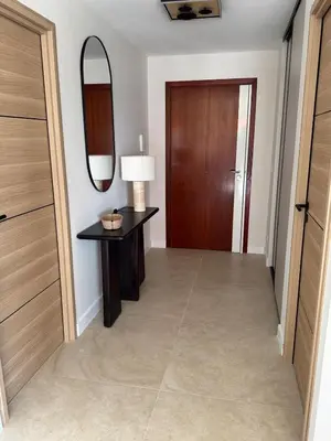a hallway with a door and a table and a mirror at Square Croisette in Cannes