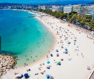 a group of people on a beach with umbrellas at Square Croisette in Cannes