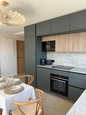 a kitchen with black cabinets and a table with chairs at Square Croisette in Cannes