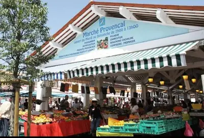 a market with people walking in front of a market with fruits and vegetables at Appartement 4 personnes à 500 mètres des plages de sable in Cannes