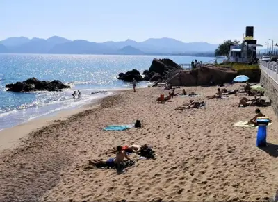 a group of people on a beach near the water at Appartement 4 personnes à 500 mètres des plages de sable in Cannes