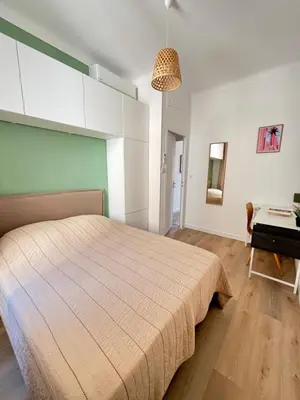 a bedroom with a large bed and a desk at Appartement 4 personnes à 500 mètres des plages de sable in Cannes