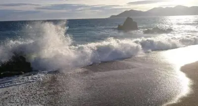 a wave hitting the shore of a beach at Appartement 4 personnes à 500 mètres des plages de sable in Cannes