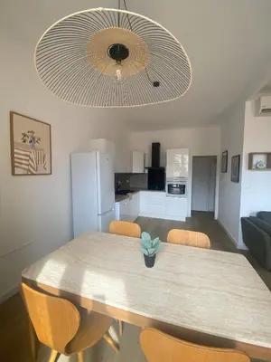 a dining room table with chairs and a large ceiling at Appartement 4 personnes à 500 mètres des plages de sable in Cannes