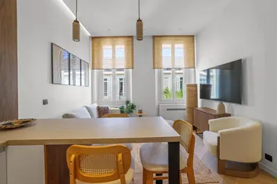 a dining room and living room with a table and chairs at Élégant situé proche du palais in Cannes