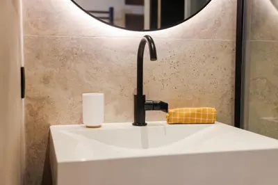 a bathroom sink with a faucet and a mirror at Élégant situé proche du palais in Cannes