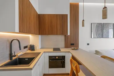 a kitchen with wooden cabinets and a sink at Élégant situé proche du palais in Cannes