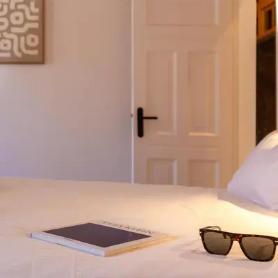 a book and glasses sitting on top of a bed at Lux PH Gem 3BR 200m palais and beach in Cannes