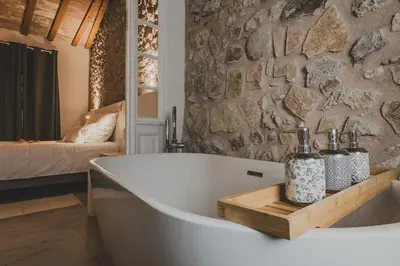 a bath tub in a bathroom with a stone wall at Lux PH Gem 3BR 200m palais and beach in Cannes