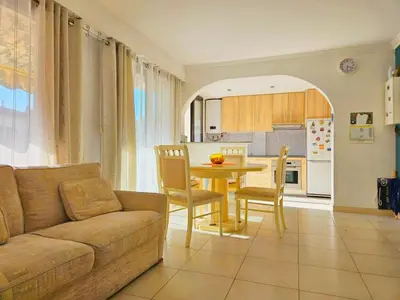 a living room with a couch and a table with chairs at Beautiful bright apartment in Cannes