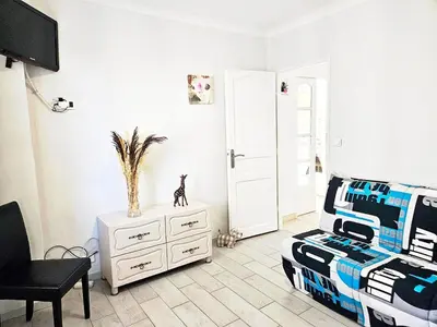 a bedroom with a bed and a chair and a tv at Beautiful bright apartment in Cannes