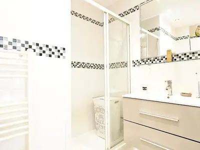 a white bathroom with a sink and a shower at Beautiful bright apartment in Cannes