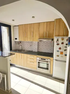 a kitchen with wooden cabinets and a white refrigerator at Beautiful bright apartment in Cannes
