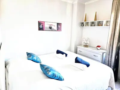two beds in a bedroom with blue pillows on them at Beautiful bright apartment in Cannes
