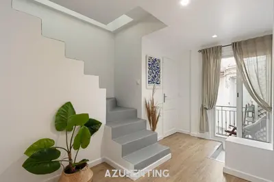 a staircase in a living room with a plant at Azurenting - Maison Césario - 3 chambres in Cannes