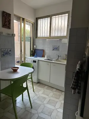 a kitchen with a table and a table and a sink at T3 Cannes Banane in Cannes