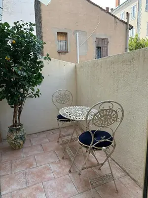 a patio with a table and two chairs and a tree at T3 Cannes Banane in Cannes