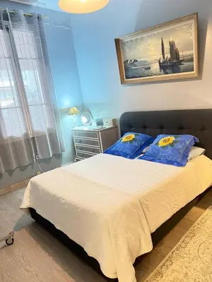 a bedroom with a bed with two blue pillows at T3 Cannes Banane in Cannes